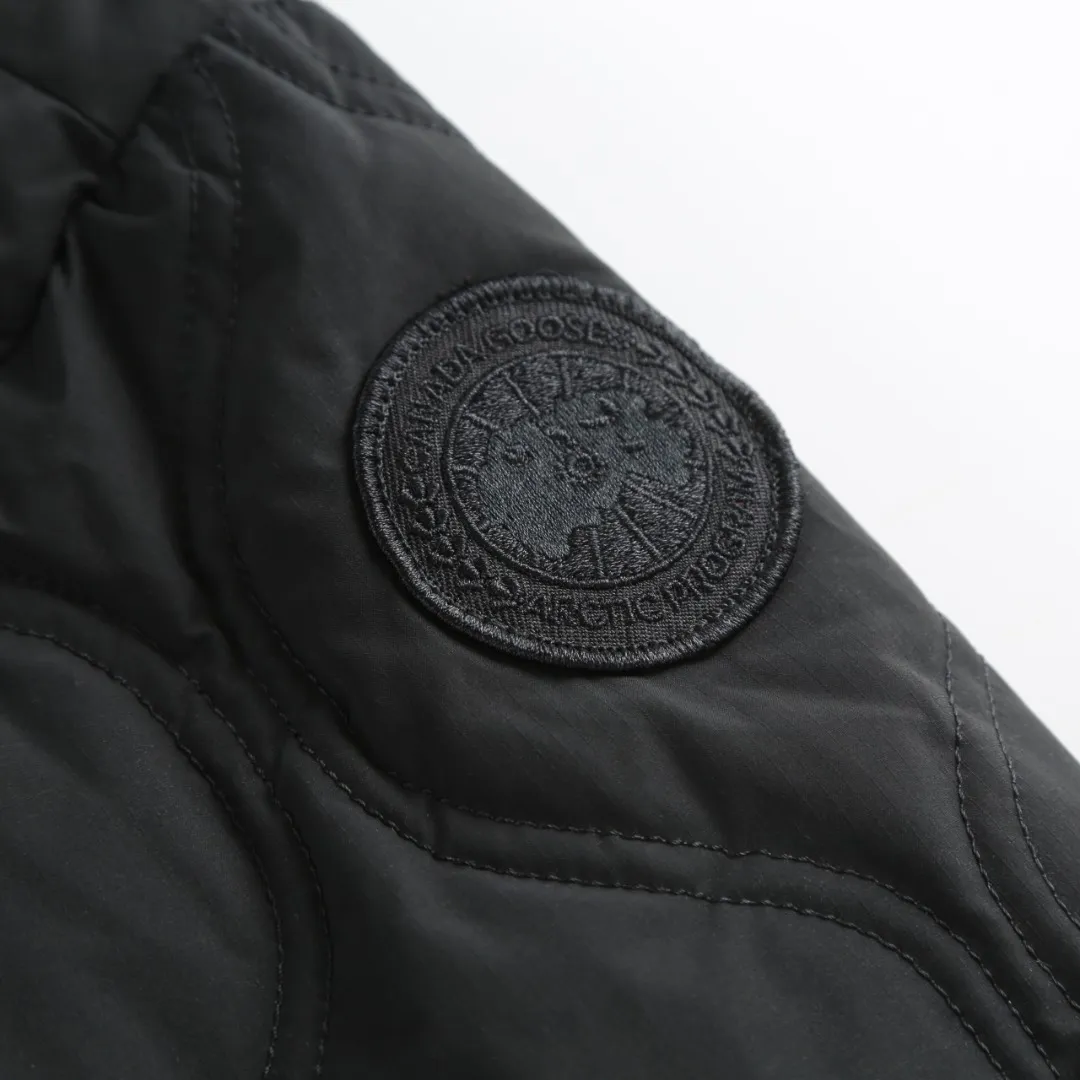 P1060 Canada Goose hooded down jacket fabric selection; nylon fabric is known for its high strength, excellent wear and tear resistance, and excellent durability. At the same time, it is light in texture, easy to move, and has excellent water-repellent function, which can effectively deal with light rain and humidity. Technology: Double-needle quilting technology is used. Double-needle quilting technology is a sophisticated sewing technology. Its core feature is to use two needles to quilt at the same time to form two parallel stitches. This design not only makes the quilting lines visually more three-dimensional, regular and refined, but more importantly, it greatly enhances the firmness of the sewing. The double lines in parallel form a more stable structure, which can effectively lock the internal filling and significantly prevent it from shifting, accumulating or velveting during wearing or washing, thereby ensuring that the thermal insulation layer is evenly distributed without cold spots, and comprehensively improves the durability and thermal efficiency of the product.    High-quality filling: It is filled with 90% selected white duck down, weighing 170g, ensuring fluffy rebound, lightness and warmth.  Accessories: one-to-one customized three-standard, one-to-one customized zipper, one-to-one customized hardware